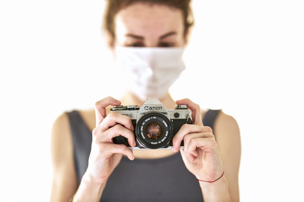 Woman in mask taking photographs